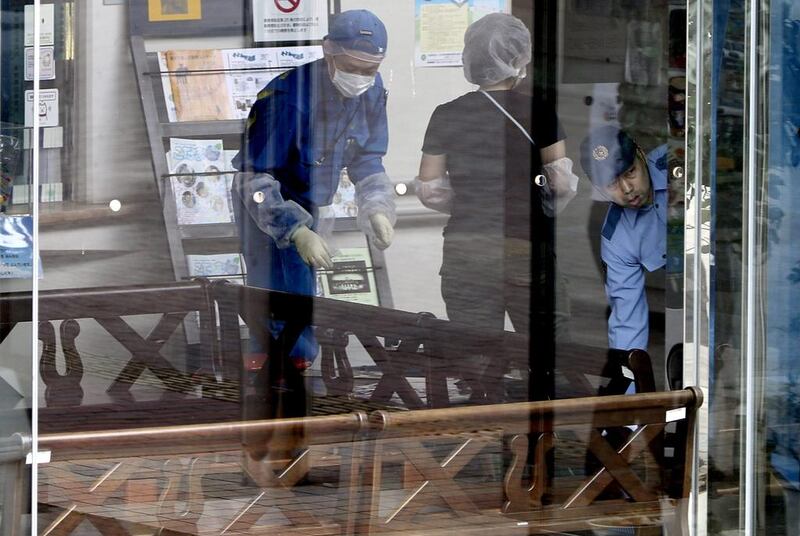 Crime scene investigators work at one of the crime scenes. Eugene Hoshiko / AP Photo