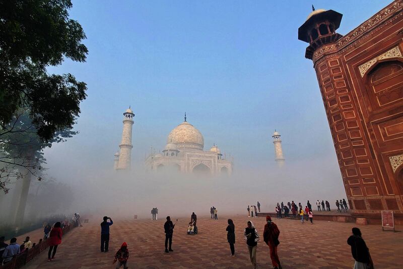 Tourists visit the Taj Mahal engulfed in fog on a winter morning in Agra. AFP