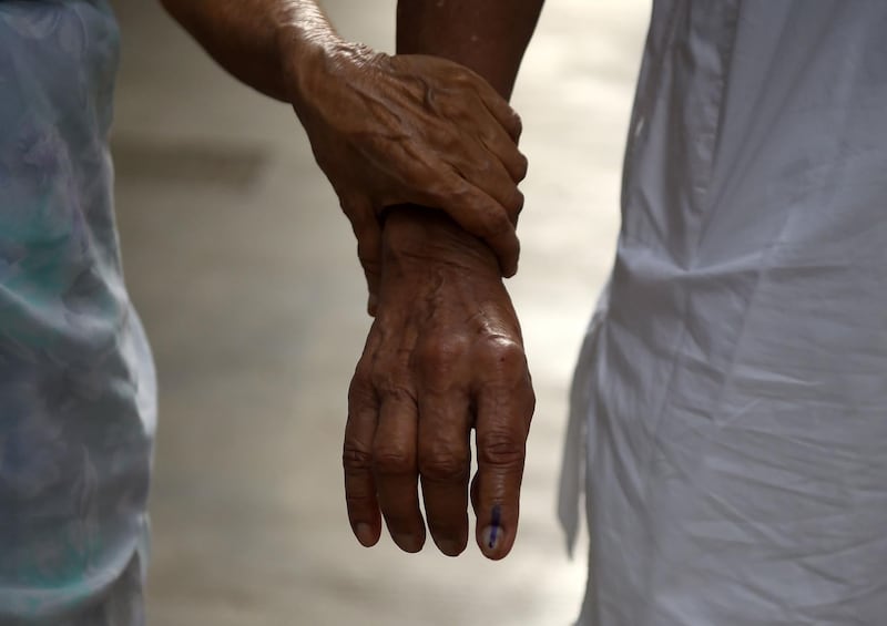 An elderly Indian couple leaves after casting their votes at a polling station during the fourth phase of general election in Mumbai on April 29, 2019.  Voting began for the fourth phase of India's general parliamentary elections.  / AFP / PUNIT PARANJPE
