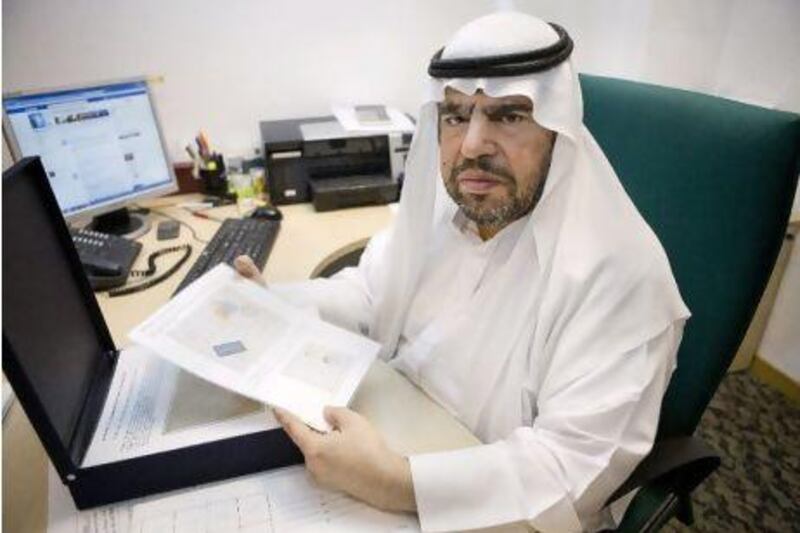 Abdulla Mohammed Tayyeb Khoory, the president of the Emirates Philatelic Association, shows a stamp from 1929.