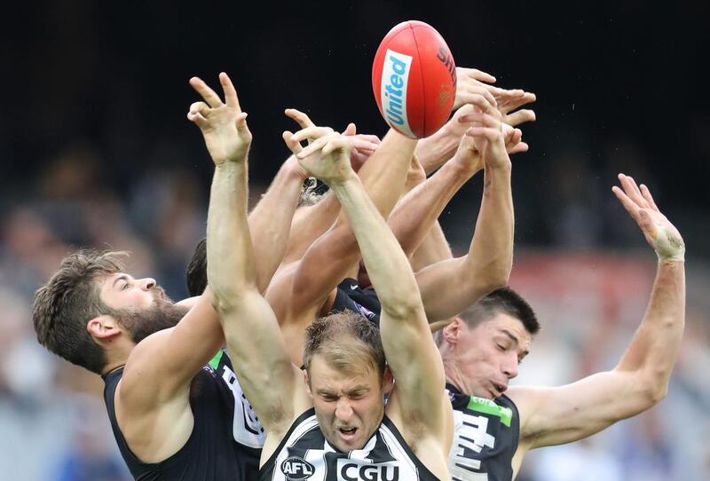 Collingwood and Carlton Aussie Rules footballers battle for the ball at the Melbourne Cricket Ground. Scott Barbour / AFL Media / Getty Images