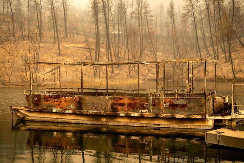 A boat scorched by the Carr Fire floats on Whiskeytown Lake in Whiskeytown, California. AP Photo / Noah Berger