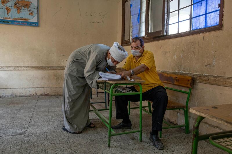 An election worker helps a man register his name to vote. AP Photo