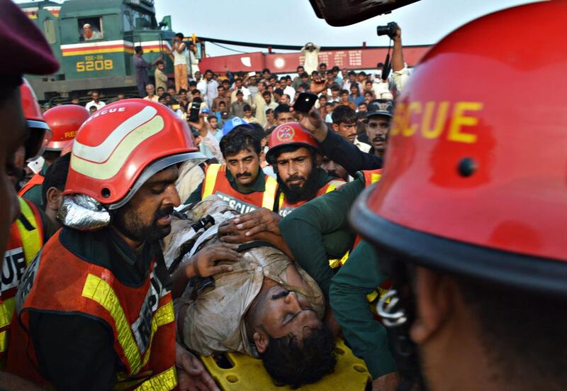 Rescue workers and civilians help a man out of the wreck of a passenger train near Buch station in Multan, Pakistan, on September 15, 2016. The goods train collided with an express passenger train near Multan, killing six people and injuring at least 90. Faisal Kareem / EPA