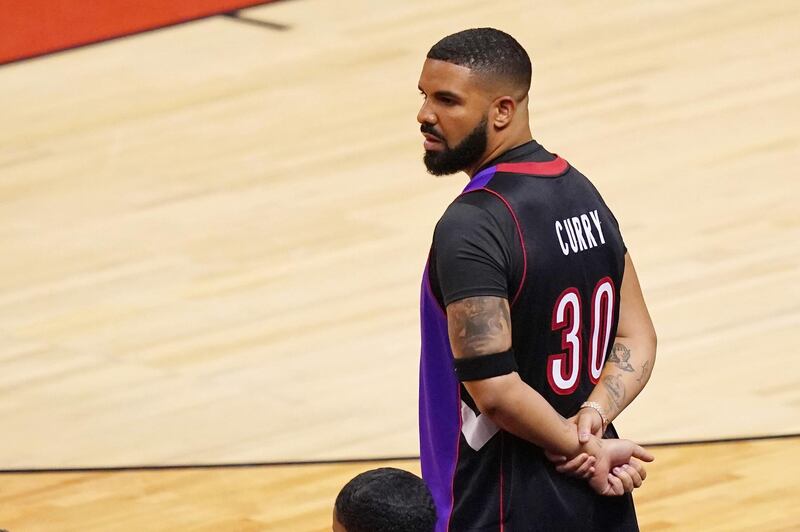 Drake watches from courtside during the game. Reuters