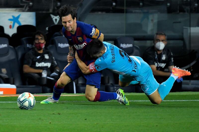 Lionel Messi (L) is rugby tackled by Leganes defender Unai Bustinza. AFP