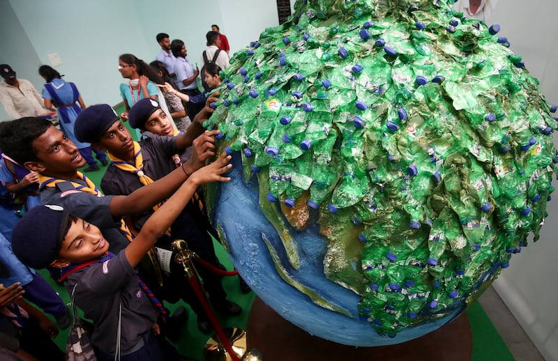 Schoolchildren look at a globe made from plastic bottles in Bangalore, India. EPA