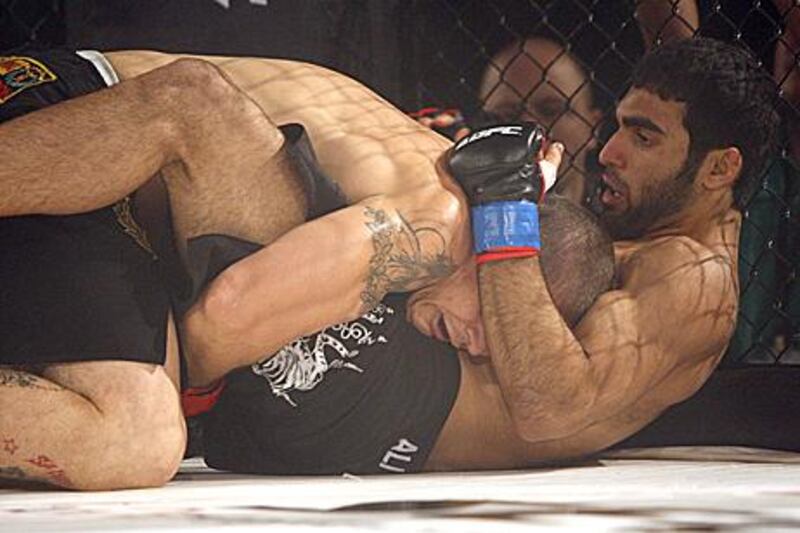 Ali Mohammed Ahli, right on floor, on his way to victory over Brazil’s Luciano Ferreira in his first professional MMA bout in Abu Dhabi last month.