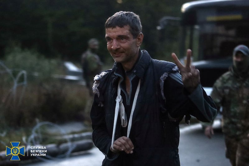 Freed Ukrainian soldier Mukhailo Dianov gives a victory sign. Reuters