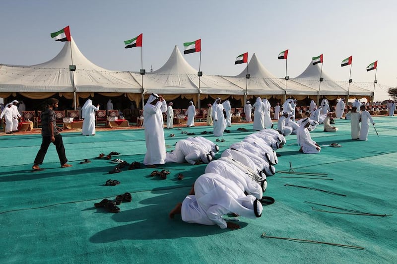 Men pray ahead of a group wedding in Al Dhaid, Sharjah, last year, in which 68 grooms married. Sarah Dea / The National
