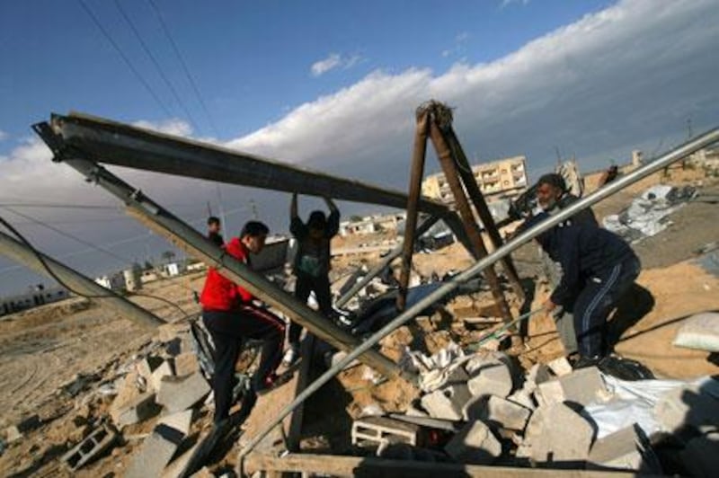 Palestinians inspect damages following Israeli air strikes in the southern Gaza Strip town of Rafah on Friday, March 19, 2010.