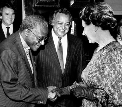 Queen Elizabeth II meeting the Anglican Archbishop of Cape Town, Desmond Tutu at a Commonwealth Day Reception at Marlborough House, London, in 1987, with Sir Shridath Ramphal, Secretary General of the Commonwealth, looking on. Photo: PA