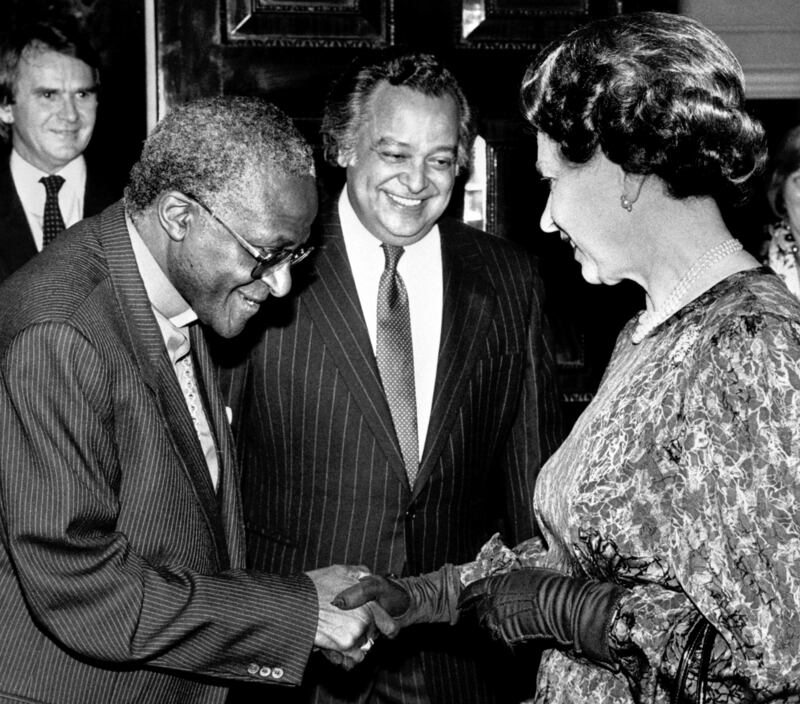 Tutu meets Britain's Queen Elizabeth II at a Commonwealth Day reception in London, with Sir Shridath Ramphal, Secretary General of the Commonwealth, looking on. PA
