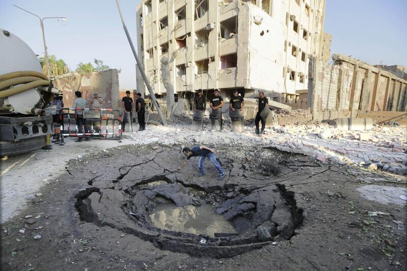 An Egyptian worker checks a crater caused by the car bombing of a Cairo police building early on August 20, 2015. Amr Nabil/AP Photo