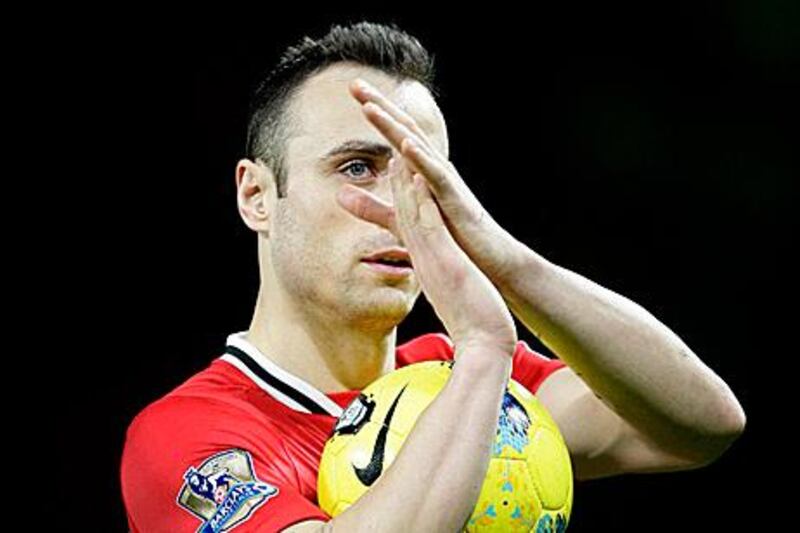 Manchester United's Dimitar Berbatov walks from the pitch with the ball after scoring 3 goals during his team's 5-0 win over Wigan in their English Premier League soccer match at Old Trafford Stadium, Manchester, England, Monday Dec. 26, 2011. (AP Photo/Jon Super)