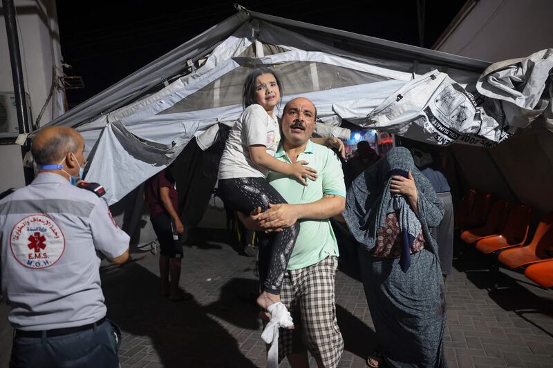 Palestinians carry an injured girl to  hospital following an Israeli strike in the southern Gaza Strip. AFP