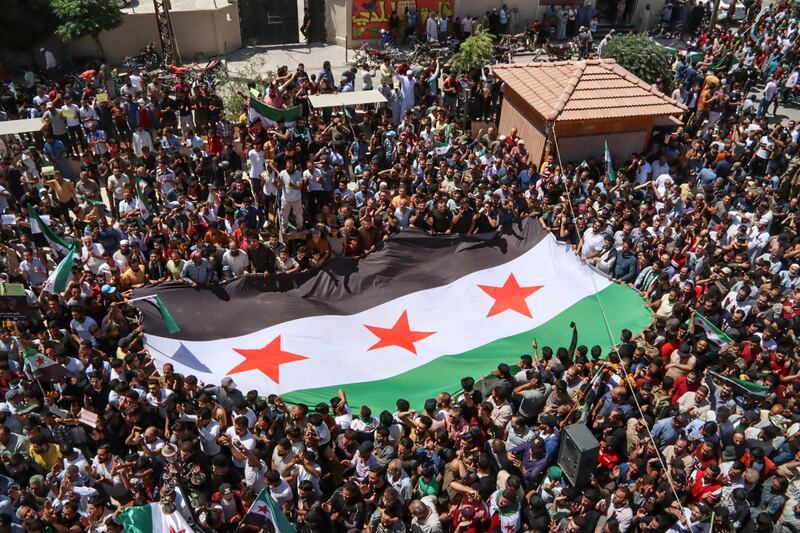 Syrians with an opposition flag in Azaz, in rebel-held north Aleppo province, protest against a proposal from the Turkish foreign minister for a reconciliation between the Syrian government and the opposition. August 12, 2022.  AFP