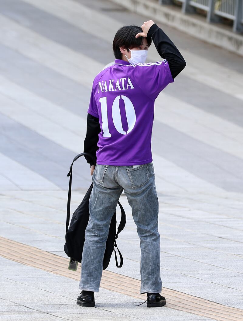 A local football fan poses outside the Yokohama International Stadium in Japan.