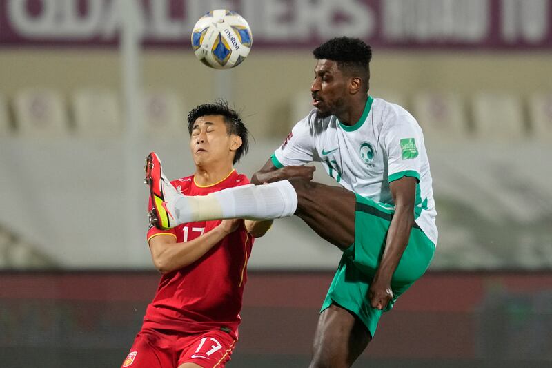 China's Dai Wai-Tsun and Saudi Arabia's Ahmed Sharahili fight for the ball, AP