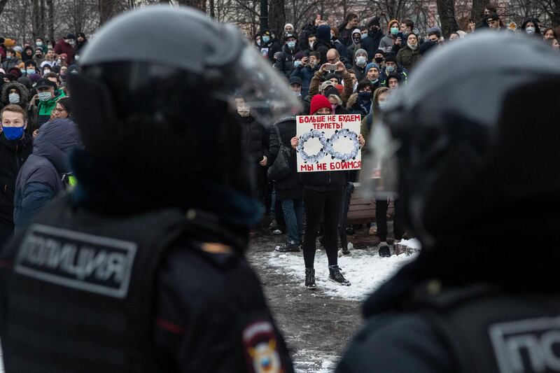 A woman holds a banner with portraits of Russian President Vladimir Putin and reads "We're not gonna take it anymore! We are not afraid", during a protest against the jailing of opposition leader Alexei Navalny in Moscow. AP Photo