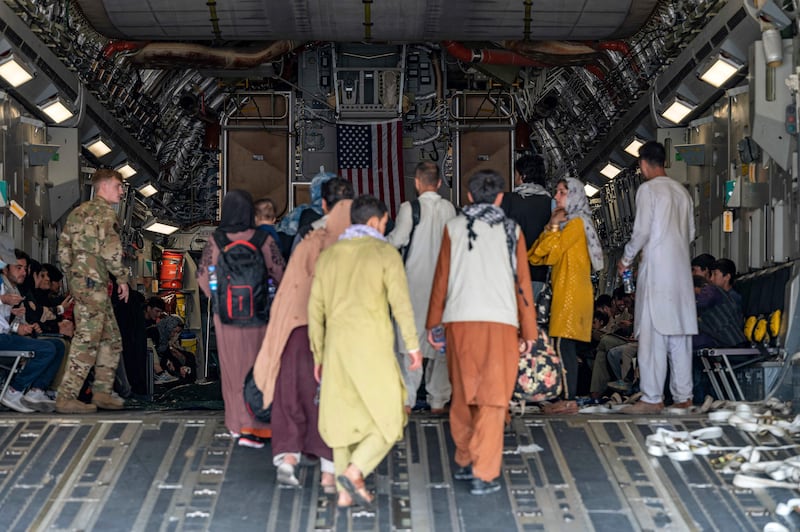 A US Air Force officer assists people aboard a C-17 Globemaster III plane at Hamid Karzai International Airport in Kabul. AFP