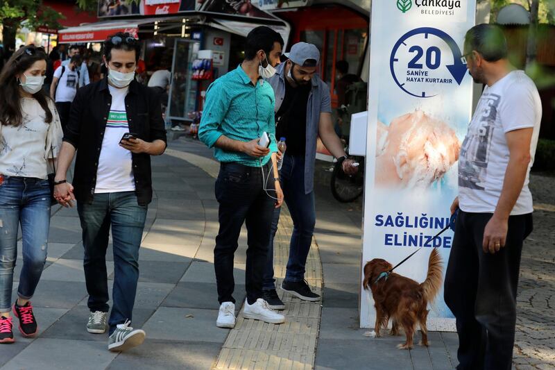 People use disinfectant at the entrance of a public garden, in Ankara, Turkey. AP Photo