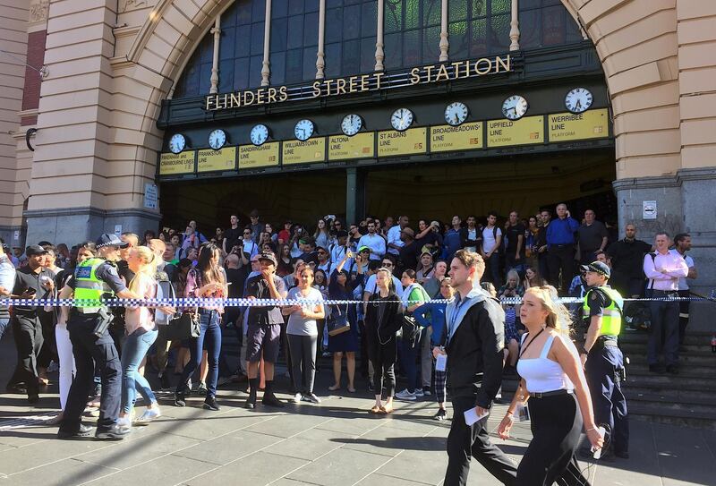 Public crowds stand behind police tape after an incident of a car ploughed into pedestrians at a crowded intersection near the in central Melbourne on Thursday. Melanie Burton / Reuters