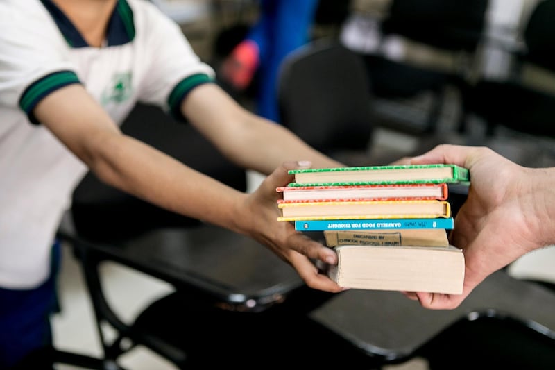 DUBAI, UNITED ARAB EMIRATES, JUNE 4, 2015. Pupils at Al Arqam Private School help Ali Al Hassani unload the books into the school's library. Photographer: Reem Mohammed / The National (Reporter: Nadeem Hanif / Section: NA) *** Local Caption ***  RM_20150604_BOOK_011.JPG