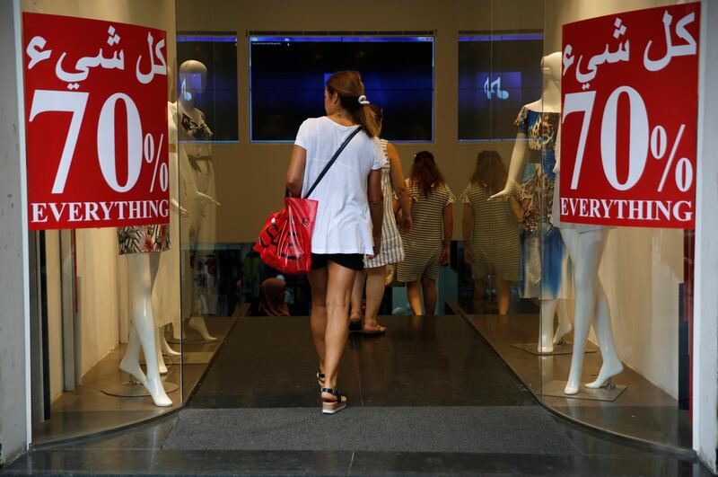 In this Monday Aug. 20, 2018 photo, a clothes shop offers big discounts, in Beirut, Lebanon. Nearly four months after Lebanon held its first general elections in nine years, politicians are still squabbling over the formation of a new government amid uncertainty over a long stagnating economy, struggling businesses and concerns over the currency. (AP Photo/Hussein Malla)