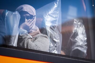 A woman stares out from a bus that will take her and other migrants for processing, in Dungeness, on the south-east coast of England, in August. AFP