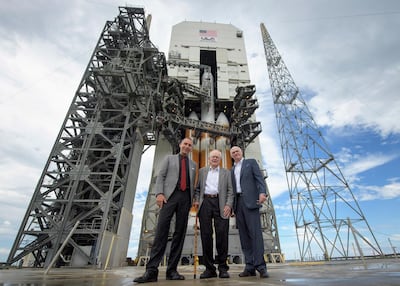 In this photo provided by NASA, astrophysicist Eugene Parker, center, stands with NASA Associate Administrator for the Science Mission Directorate Thomas Zurbuchen, left, and United Launch Alliance President and Chief Executive Officer Tony Bruno in front of the ULA Delta IV Heavy rocket with NASA's Parker Solar Probe onboard, Friday, Aug. 10, 2018 at Cape Canaveral Air Force Station, Fla. Humanity's first-ever mission into a part of the Sun's atmosphere called the corona, is scheduled to launch early Saturday. (Bill Ingalls/NASA via AP)