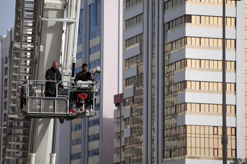 Abu Dhabi, United Arab Emirates, May 7, 2013: 
Passersby look on as emergency units finish up working on a fire, which seems to have gutted an apartment on a third floor of an older building on Airport Road near 13th Street in Abu Dhabi on Tuesday late afternoon, May 7, 2013.
Silvia Razgova / The National

