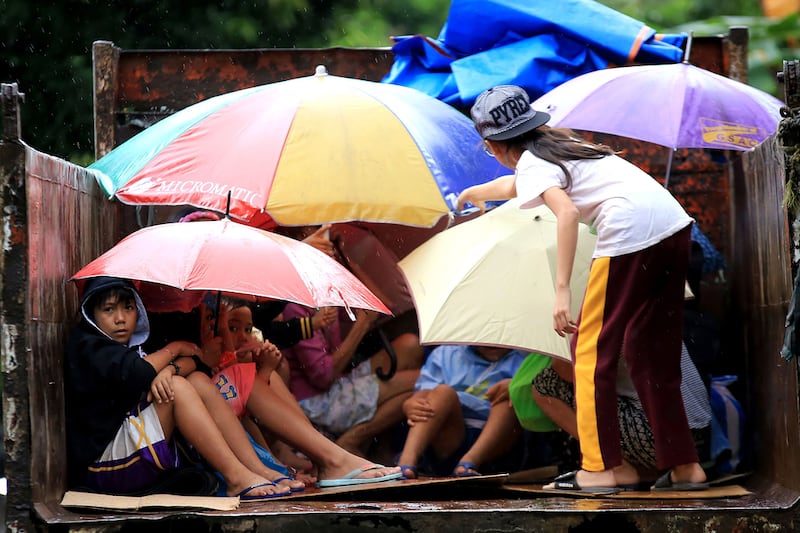 Young residents sit in a truck after the local government implemented preemptive evacuations at Barangay Matnog, Daraga, Albay province on December 25, 2016, due to typhoon Nock-Ten.  AFP

