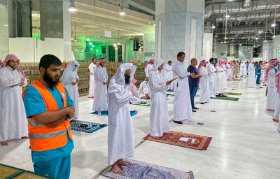 Muslim worshippers perform the "Tarawih" nightly prayer during the holy month of Ramadan, while keeping their distance amid the COVID-19 pandemic, at the Grand Mosque, Islam's holiest site, in the Saudi city of Mecca, late on May 8, 2020. Saudi Authorities allowed for a limited number of worshippers to enter the Grand Mosque to perform prayers during Ramadan, amid unprecedented bans on family gatherings and mass prayers due to the novel coronavirus (COVID-19) pandemic. / AFP / STR
