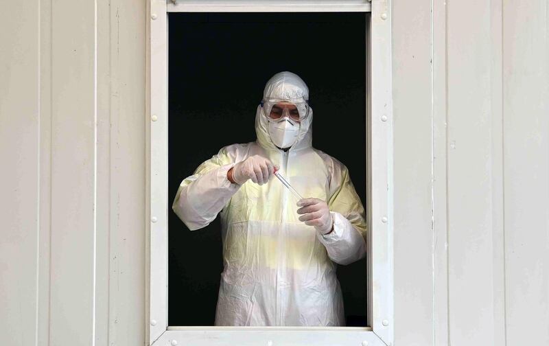 A medical staff holds a testing tube in a car testing station in Erkheim, southern Germany. AFP