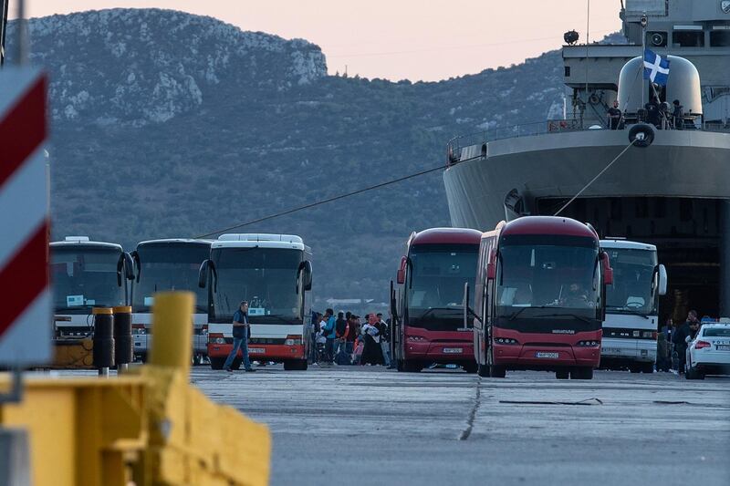 Migrants wait to board on buses after their disembarkation at the port of Elefsina, near Athens, on Saturday, Nov. 2, 2019. The transfer of migrants from overcrowded camps on the islands to the Greek mainland continued this weekend, with 415 arriving Saturday afternoon at the port of Elefsina west of Athens and at least another 400 expected Sunday or early Monday. (AP Photo/Yorgos Karahalis)