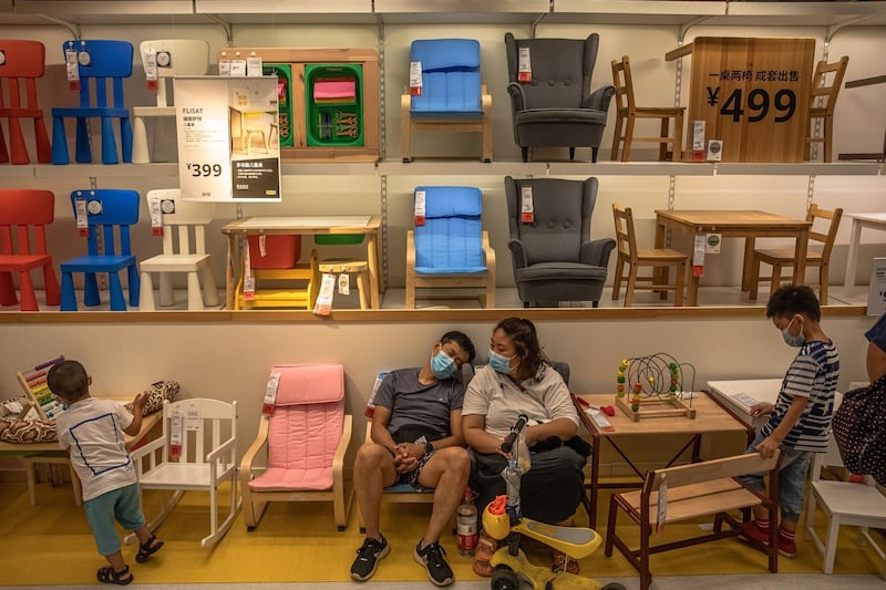 Shoppers wearing protective face masks rest as they visit an IKEA store in Beijing, China.  EPA