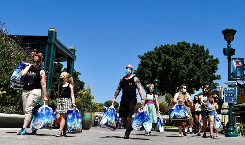 Visitors to the Disneyland Resort head toward the exit after a morning of shopping on the reopening day of the Downtown Disney District.  AP
