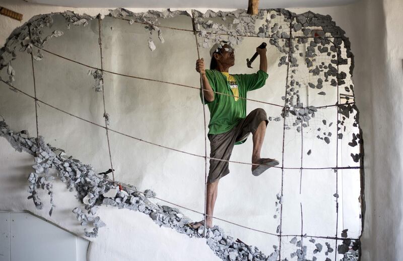 A worker demolishes a wall of the West Cove Hotel on the Philippine island of Boracay on April 26, 2018. Noel Celis / AFP Photo