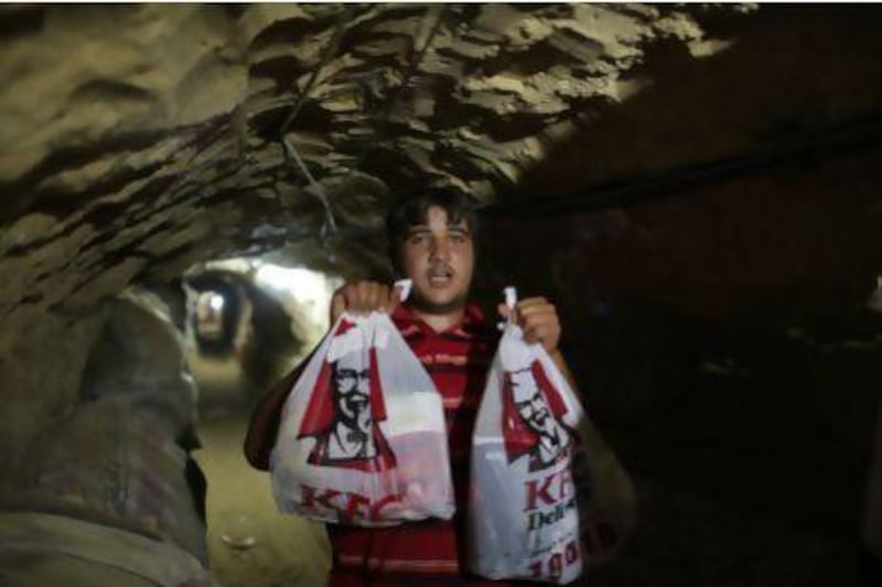 A delivery man holds KFC food in the underground tunnel beneath the Gaza-Egypt border in the southern Gaza Strip city of Rafah.