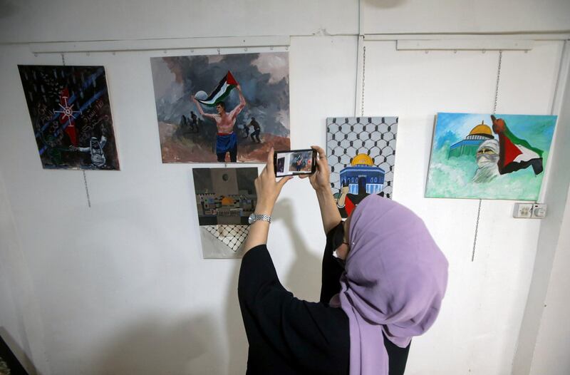 An Iraqi takes pictures of pro-Palestinian artwork at an art studio in Basra, Iraq. Reuters