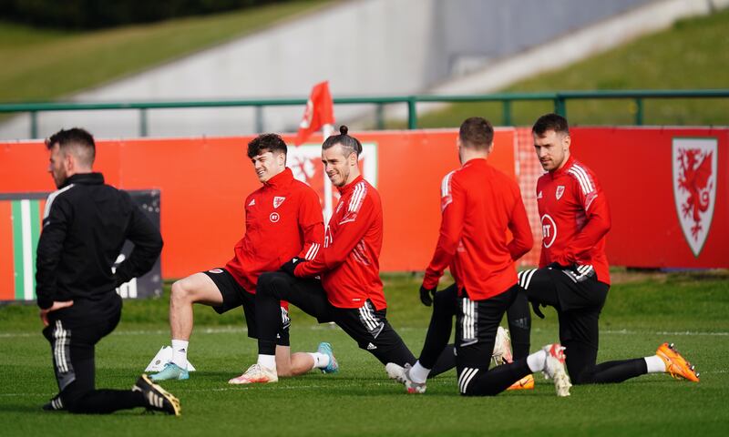 Wales' Gareth Bale and Daniel James stretching during training. PA