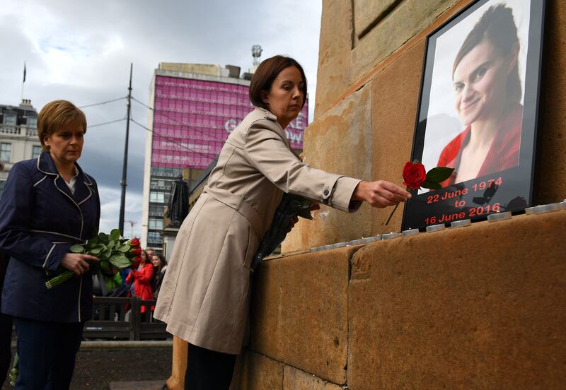 First minister of Scotland Nicola Sturgeon, left, and leader of Scottish Labour Kezia Dugdale place roses at a memorial for murdered Labour MP Jo Cox, in Glasgow in 2016