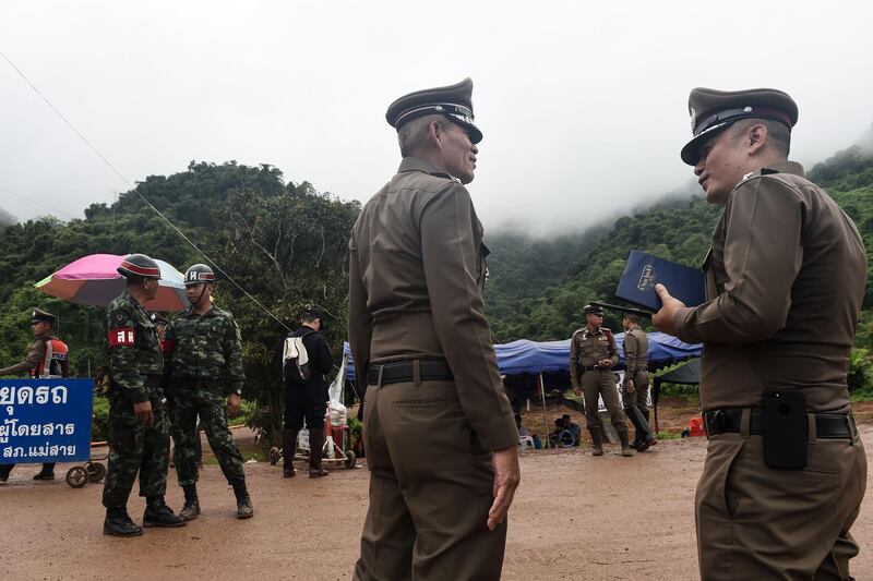 Police and soldiers guard a road leading to the Tham Luang cave area. AFP
