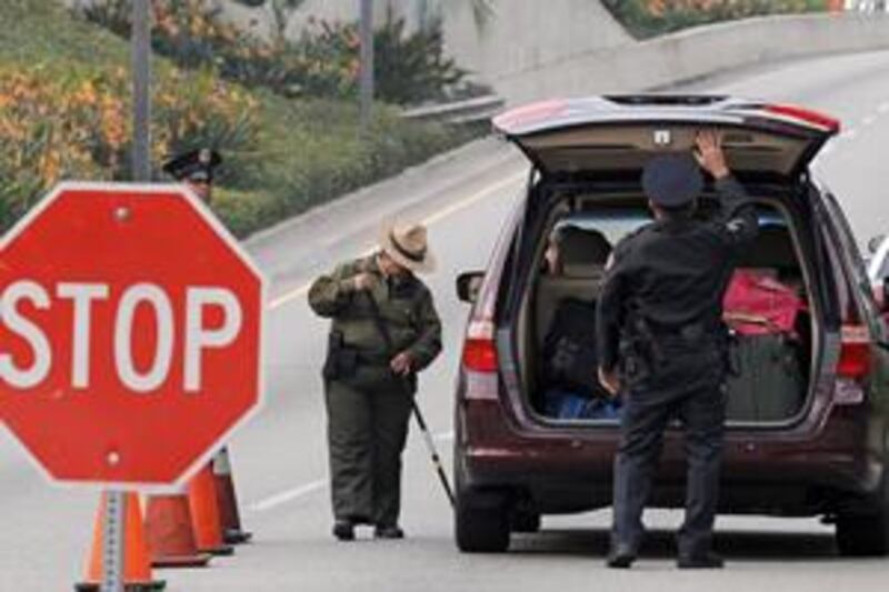 Police officers search a passenger car arriving at Los Angeles International Airport at a security checkpoint on December 26.