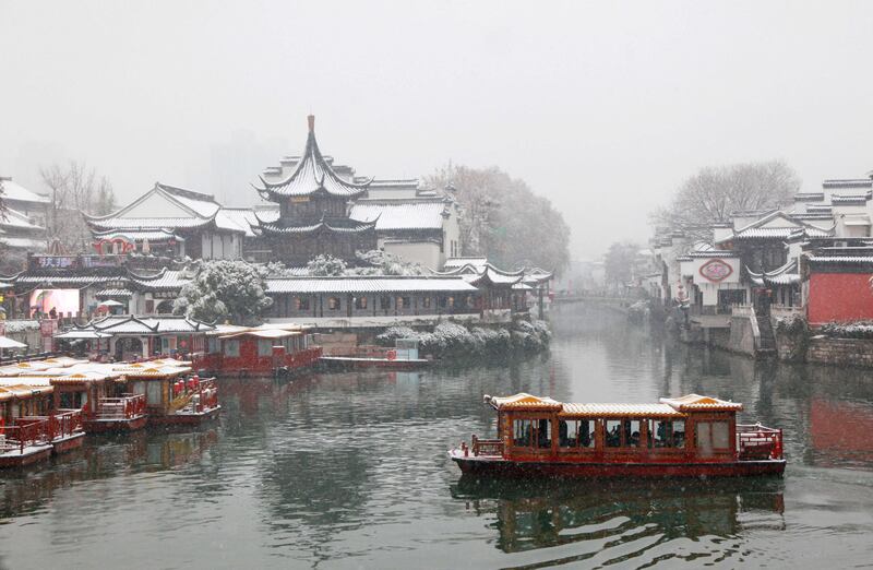 A boat on a canal in the Confucius Temple Scenic Area during snowfall in Nanjing, in China's eastern Jiangsu province. AFP