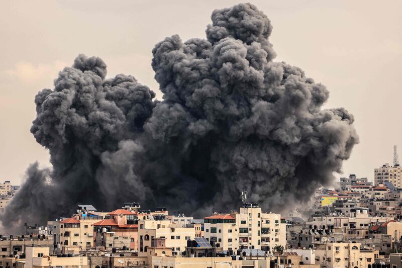 A plume of smoke rises over Gaza city as Israeli air strikes hit. AFP