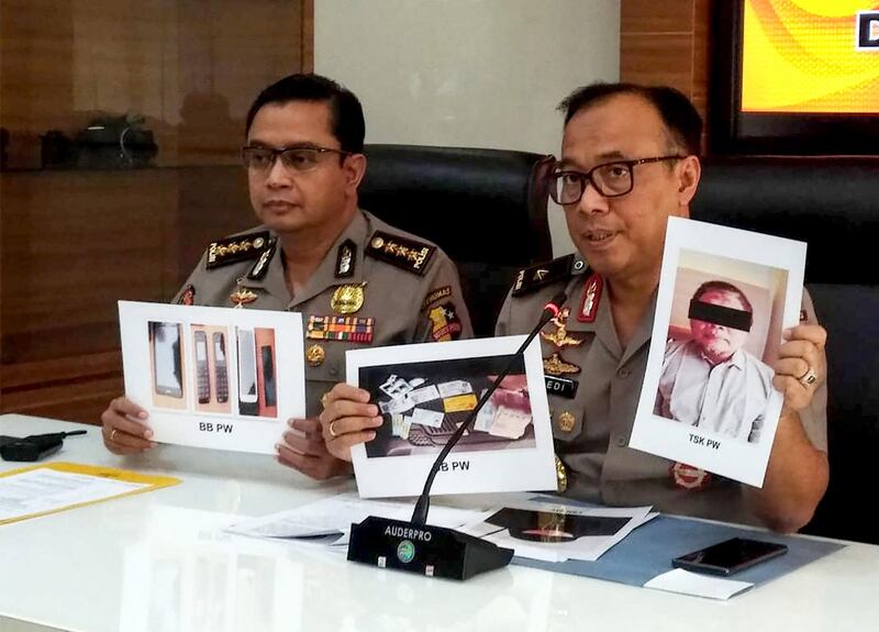 Indonesian police personnel show photographs of leader Para Wijayanto and various seized items, at a press conference in Jakarta on July 1, 2019, as Wijayanto was detained by counter-terrorism police with his wife on at a hotel in Bekasi, a city on the outskirts of the capital Jakarta. Indonesian police said on July 1 they had arrested the leader of Al Qaeda-linked extremist network Jemaah Islamiah, which carried out the 2002 Bali bombings that killed more than 200 people.    / AFP / STR
