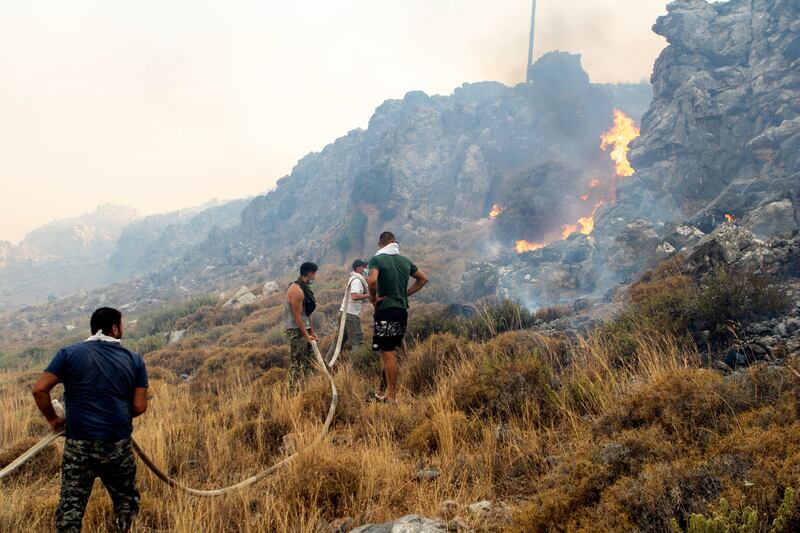 Volunteers try to put out a wildfire in Kiotari village, on Rhodes island. EPA