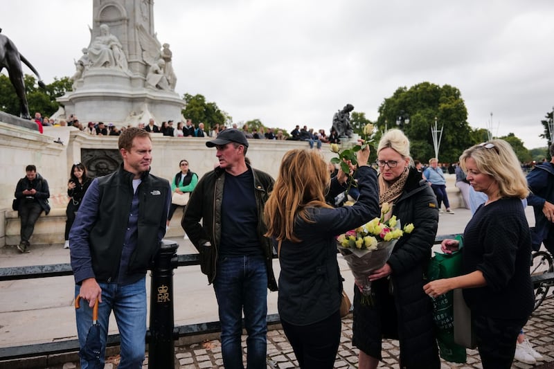 Well-wishers prepare a bouquet of flowers to leave at Buckingham Palace, on the first day of public mourning after the death of Queen Elizabeth II. Bloomberg